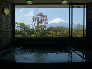 A room with a large window overlooking a mountain and a garden. - Kawaguchiko Station Inn (Fujikawaguchiko)