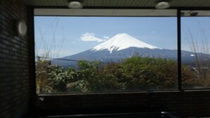 A room with a large window offering a view of a snow-capped mountain.