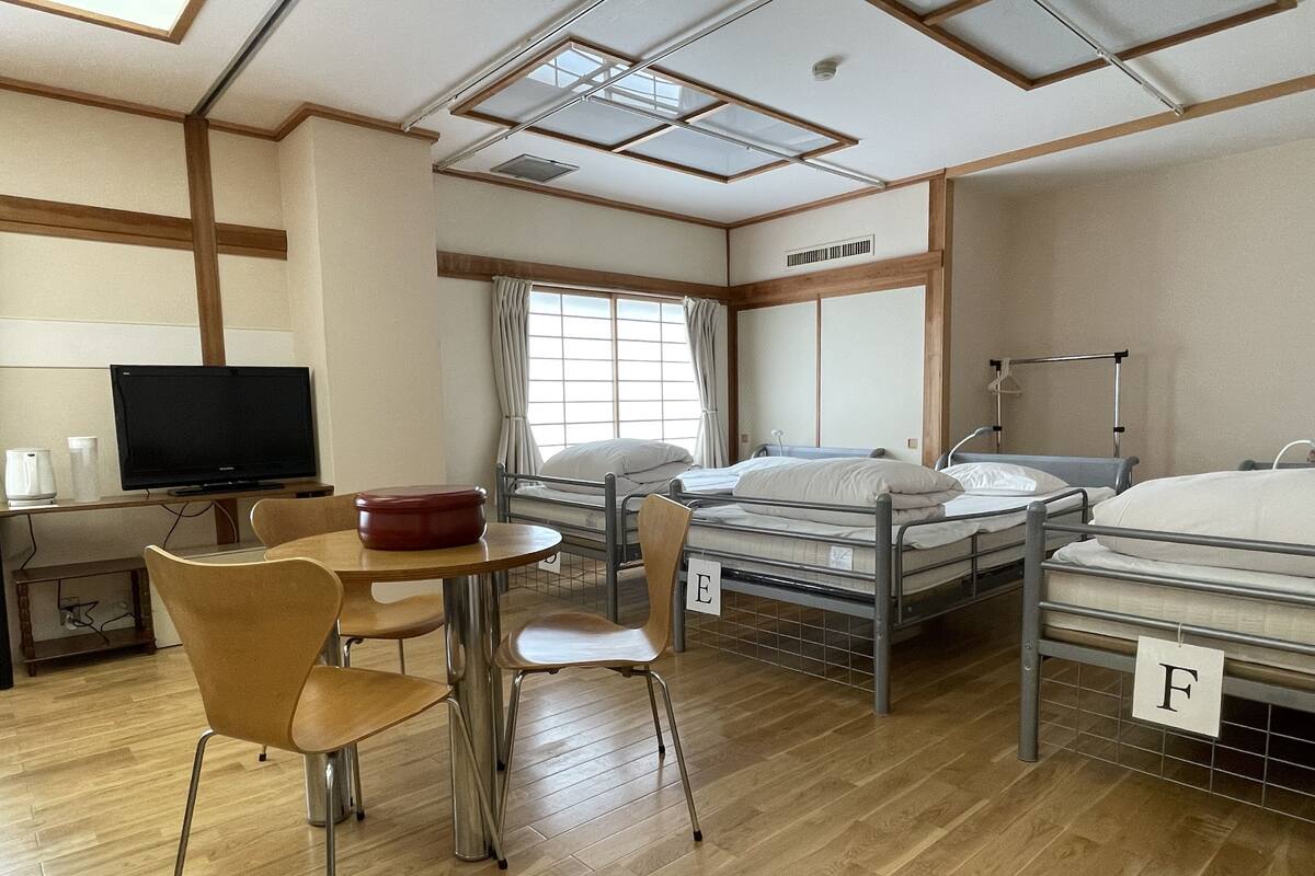 Hotellihuone, jossa on sänky, työpöytä, tuoli, televisio ja ikkuna.