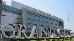 Un edificio moderno con las palabras 'CONVENTION & EXHIBITION' en la fachada y grandes letras que deletrean 'GRAND' al frente.
