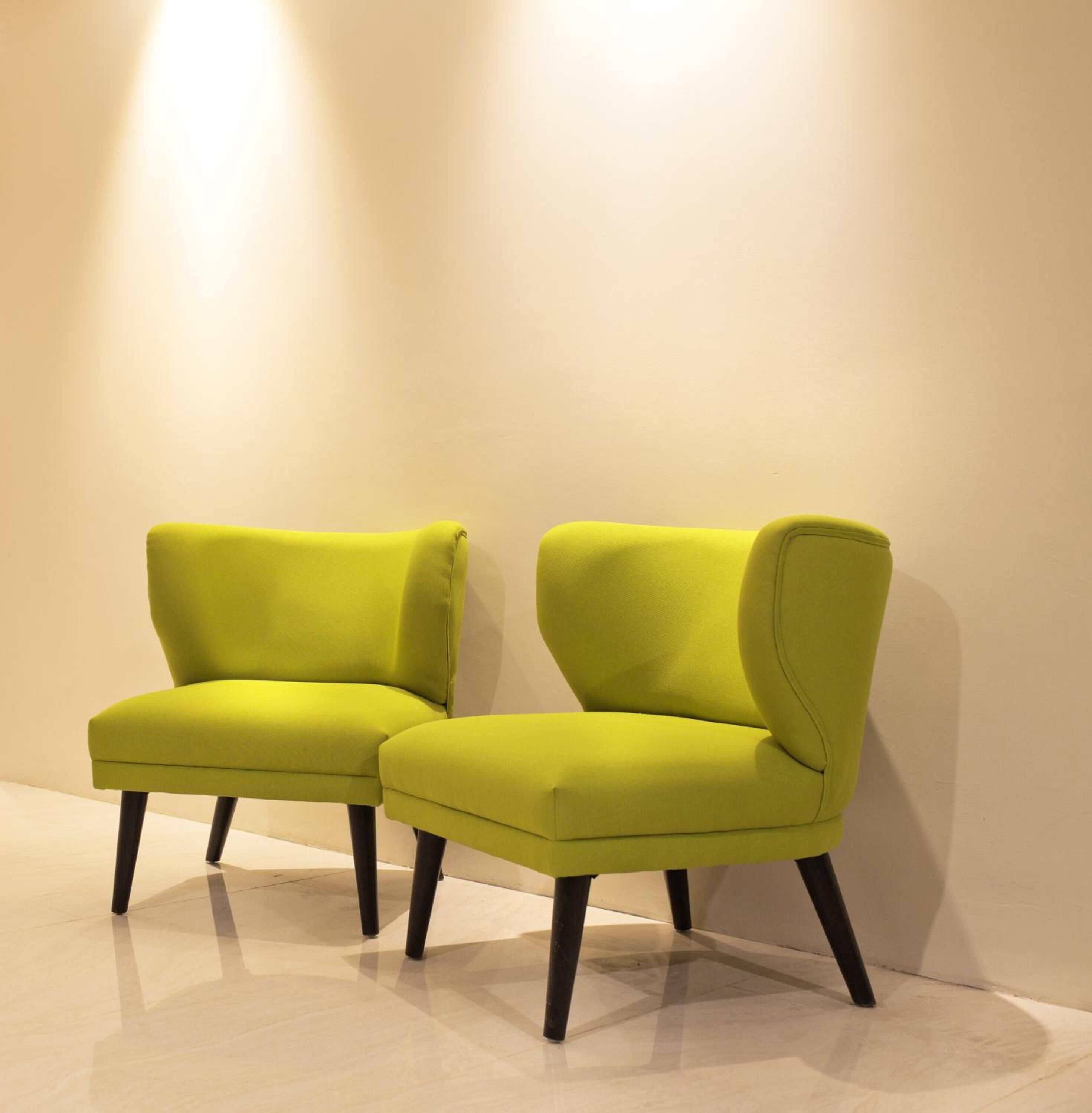 Two modern chairs with black legs and a light-colored floor.