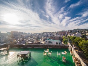 A rooftop terrace with a pool, tables, and chairs. - Itaewon Inn (Seoul)