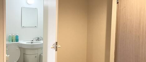 A bathroom with a toilet, sink, and mirror.