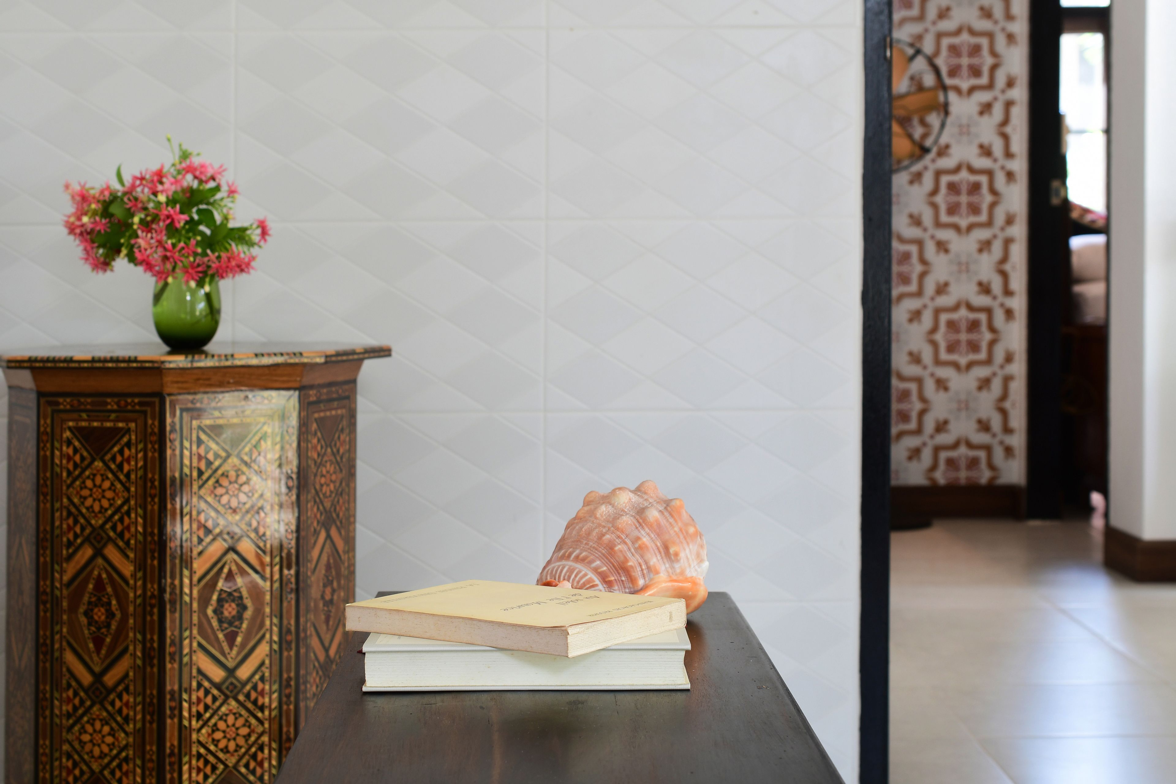 A wooden table with a book and a vase of flowers.