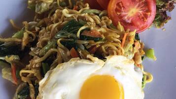 A plate of stir-fried noodles with vegetables and a fried egg.