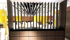 A reception area with a wooden reception desk, a yellow wall, and a ceiling with exposed beams. - Century Hotel Taoyuan (Taoyuan City)