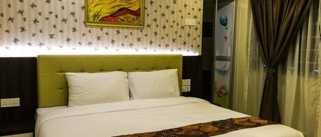 Habitación de hotel con una cama grande, un cabecero verde, un papel tapiz estampado con flores y un cuadro sobre la cama.
