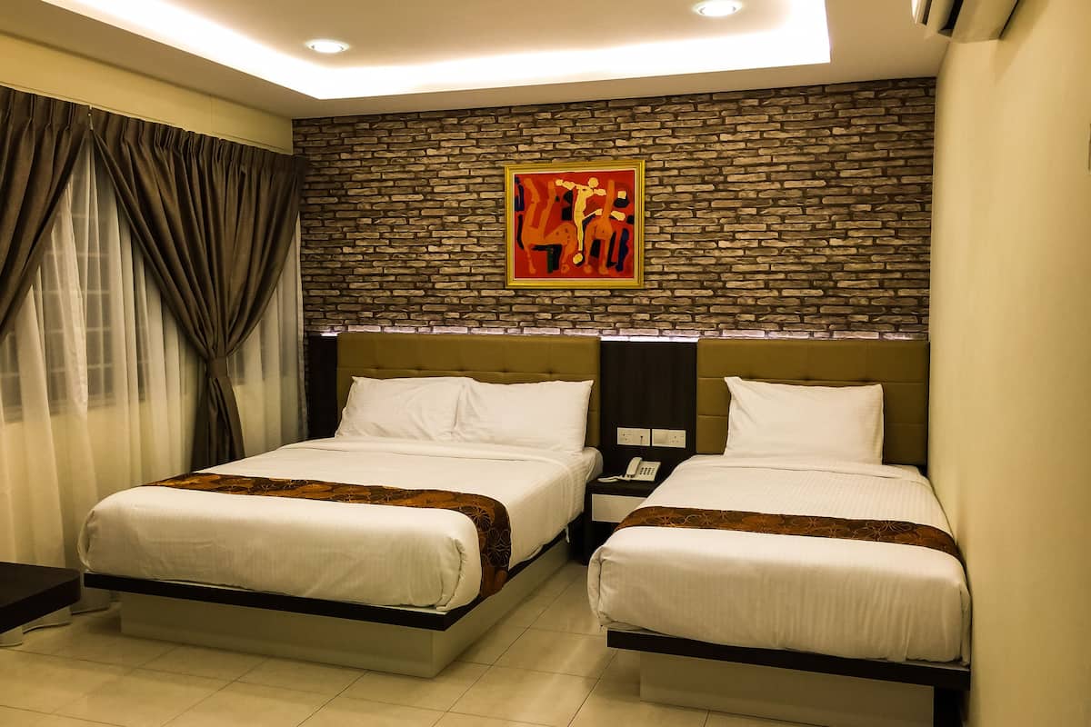 Habitación de hotel con dos camas, una pared de piedra y un cuadro.