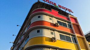 Un hôtel à plusieurs étages, dont la façade rouge et jaune est particulièrement remarquable.