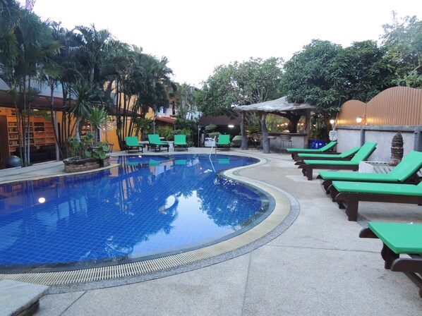 A swimming pool with green lounge chairs and a covered seating area. - Khaolak Grand City (Takua Pa)