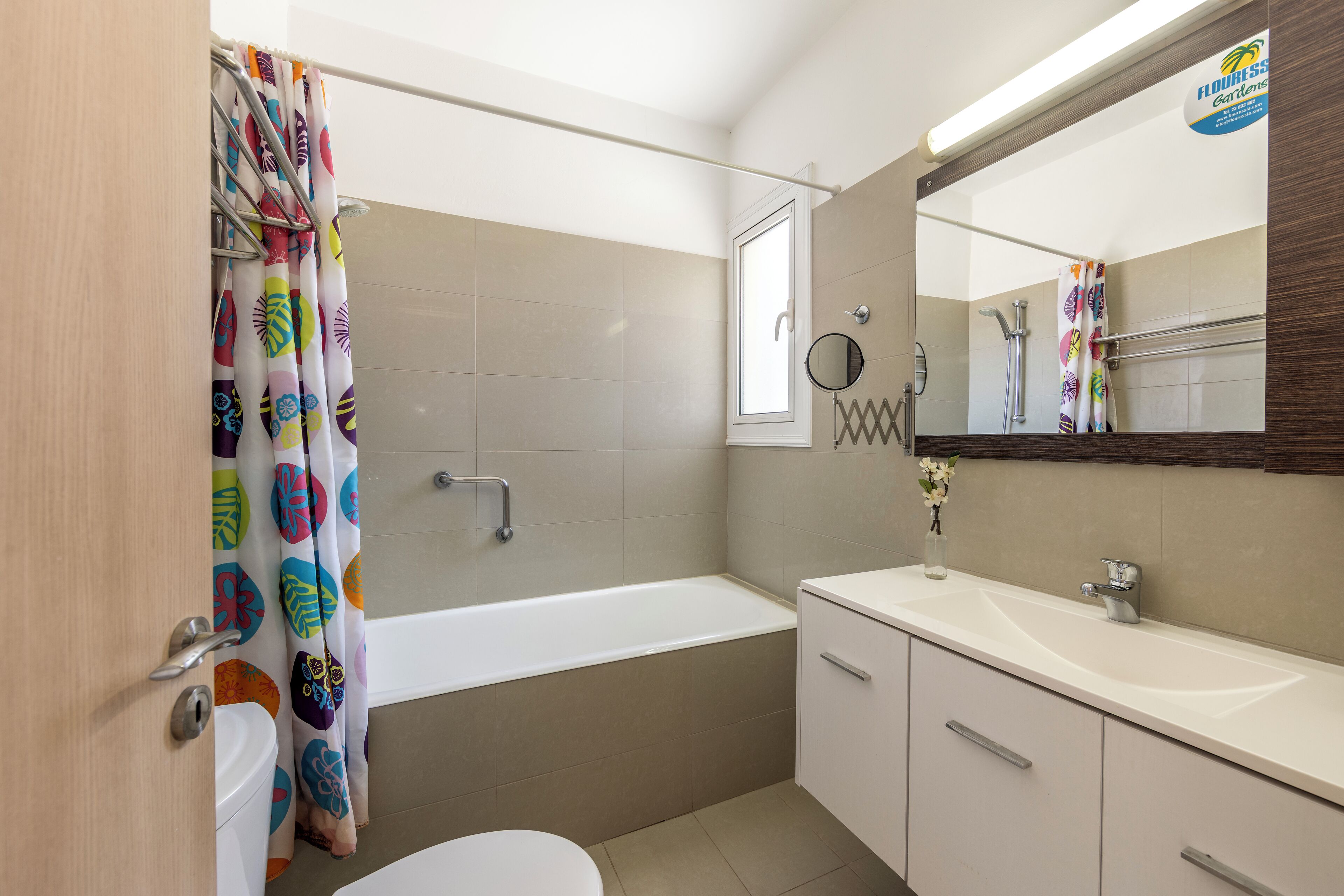 A bathroom with a bathtub, toilet, sink, and a mirror.