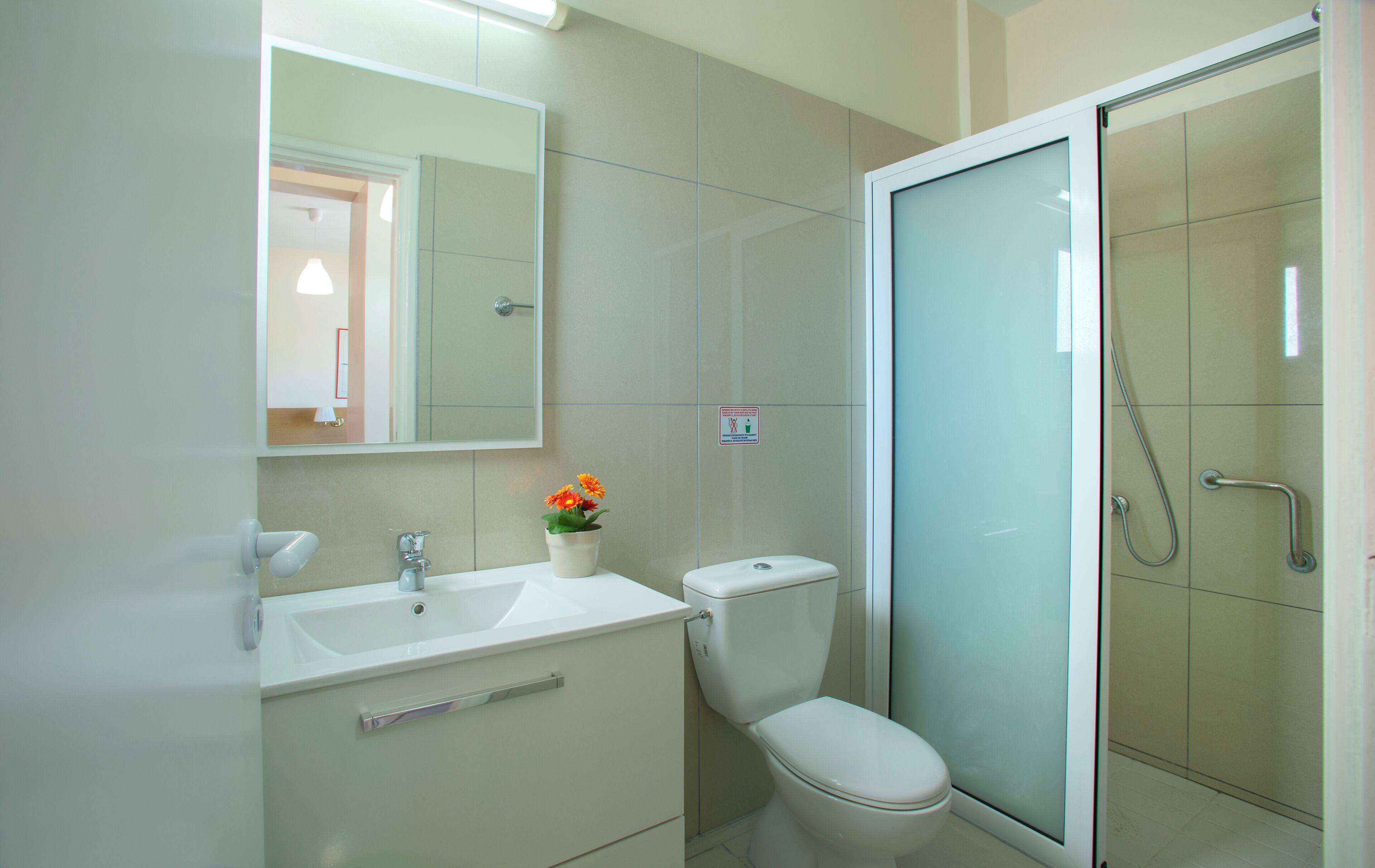 A bathroom with a toilet, sink, and shower.