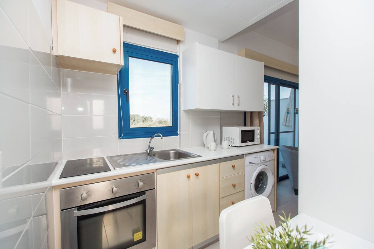 A modern kitchen with a built-in oven, microwave, and sink.