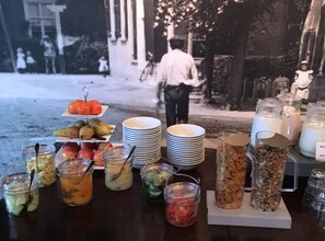 Una mesa de buffet con diversos alimentos y bebidas, entre ellos frutas, verduras y productos lácteos.