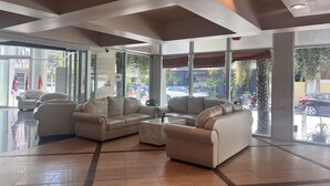 A spacious lobby with leather sofas and a coffee table, large windows offering views of the street, and a modern ceiling design. - NEO Hatyai Hotel (Hat Yai)