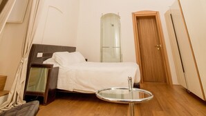 A bedroom with a bed, a mirror, a wooden door, and a ceiling with floral patterns. - Dimora Intini (Noci)