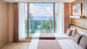 Chambre Triple Royale, plusieurs lits, balcon, vue partielle sur l'océan | Literie de qualité supérieure, rideaux occultants, chambres insonorisées
