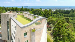 Un edificio moderno con jardín en la azotea y vistas al mar.