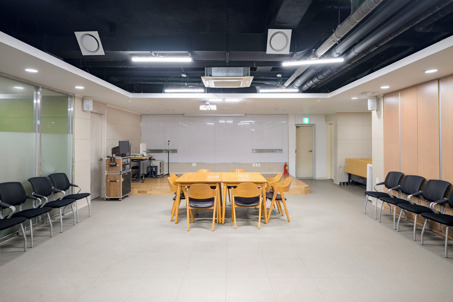 Una sala conferenze con un grande tavolo e sedie, una lavagna e un proiettore.