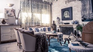 A living room with a sofa, chairs, a coffee table, and a fireplace. - Pandora Villas (Hersonissos)