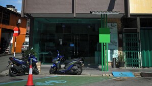 Un hotel con un cartel que dice "Nür HOTEL" y un espacio para estacionar bicicletas, con superficie verde.