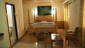 Un dormitorio con cama con dosel, una mesita de noche de madera, una silla, una mesa y un espejo.
