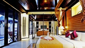 A modern hotel room with a large bed, a wooden headboard, a television, and a balcony with a view. - The Kara Pool Villa (Sa Khu)