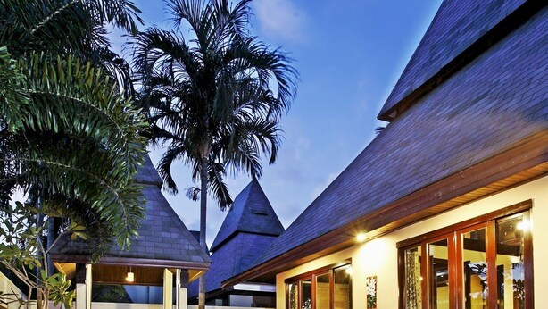 A swimming pool with a tiled deck, surrounded by a wooden deck and palm trees. - The Kara Pool Villa (Sa Khu)