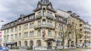 A historic building with a corner turret, multiple windows, and a statue on the facade. - Hotel Waldhorn (Bern)