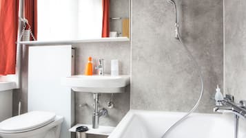 A modern bathroom with a toilet, sink, and bathtub.