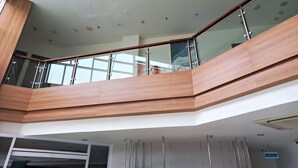 A modern interior with a wooden staircase, glass railings, and recessed ceiling lights. - Hotel 88 Kedoya Jakarta (Jakarta)