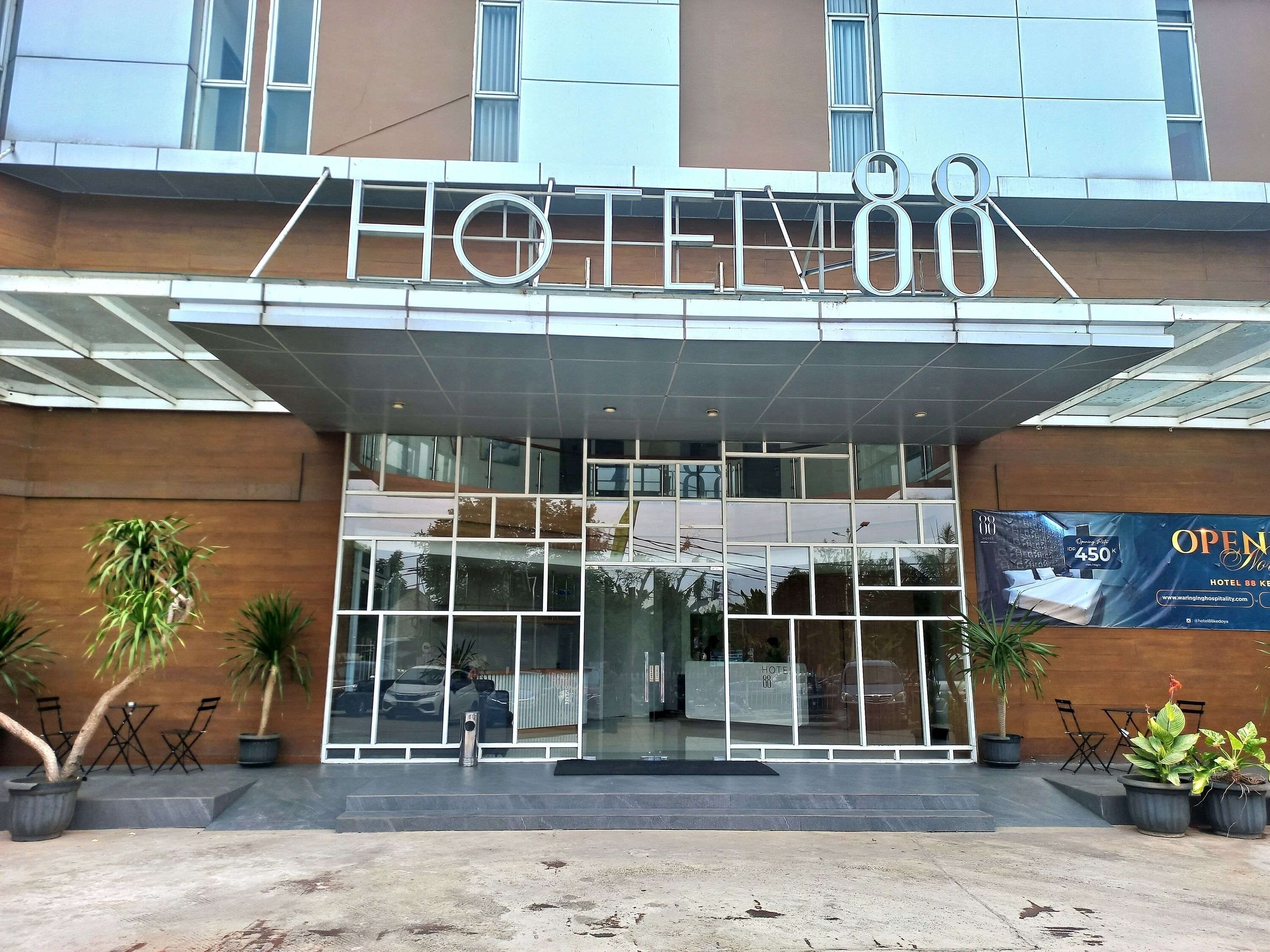 The exterior of Hotel 88 with a modern design, featuring a large glass entrance and a sign above the doors.