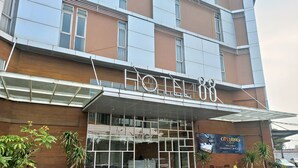 A modern hotel with a prominent entrance, large glass windows, and a sign indicating a price of 450. - Hotel 88 Kedoya Jakarta (Jakarta)