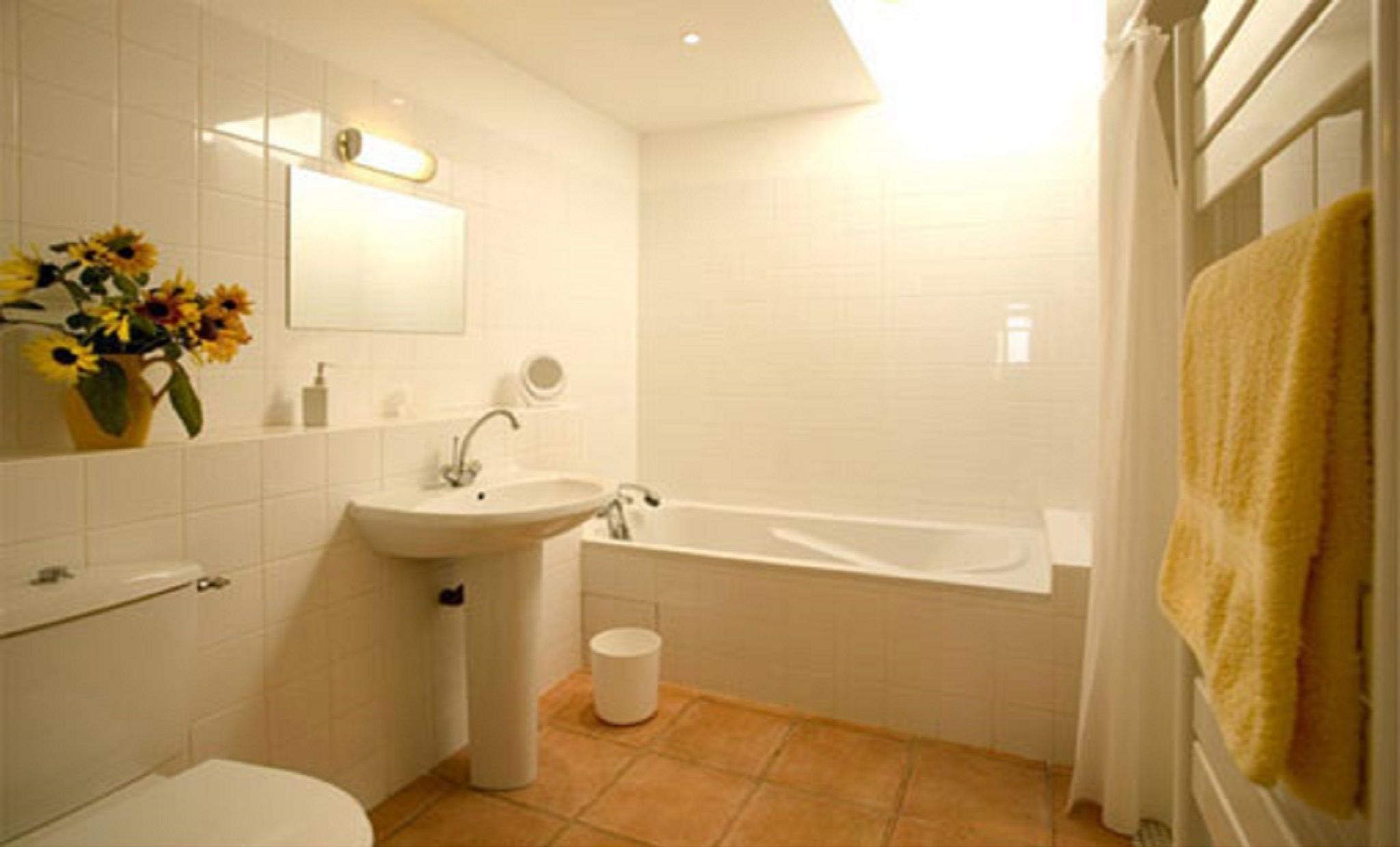 Un baño con lavamanos, espejo y bañera.