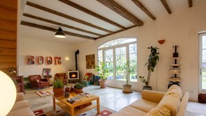 A cozy living room with a fireplace, comfortable seating, and a bookshelf. - Domaine Maison DoDo (Lamonzie-Saint-Martin)