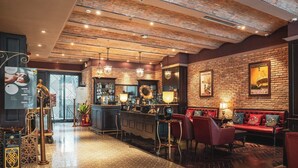 A spacious lobby with a bar area, seating, and a patterned floor.