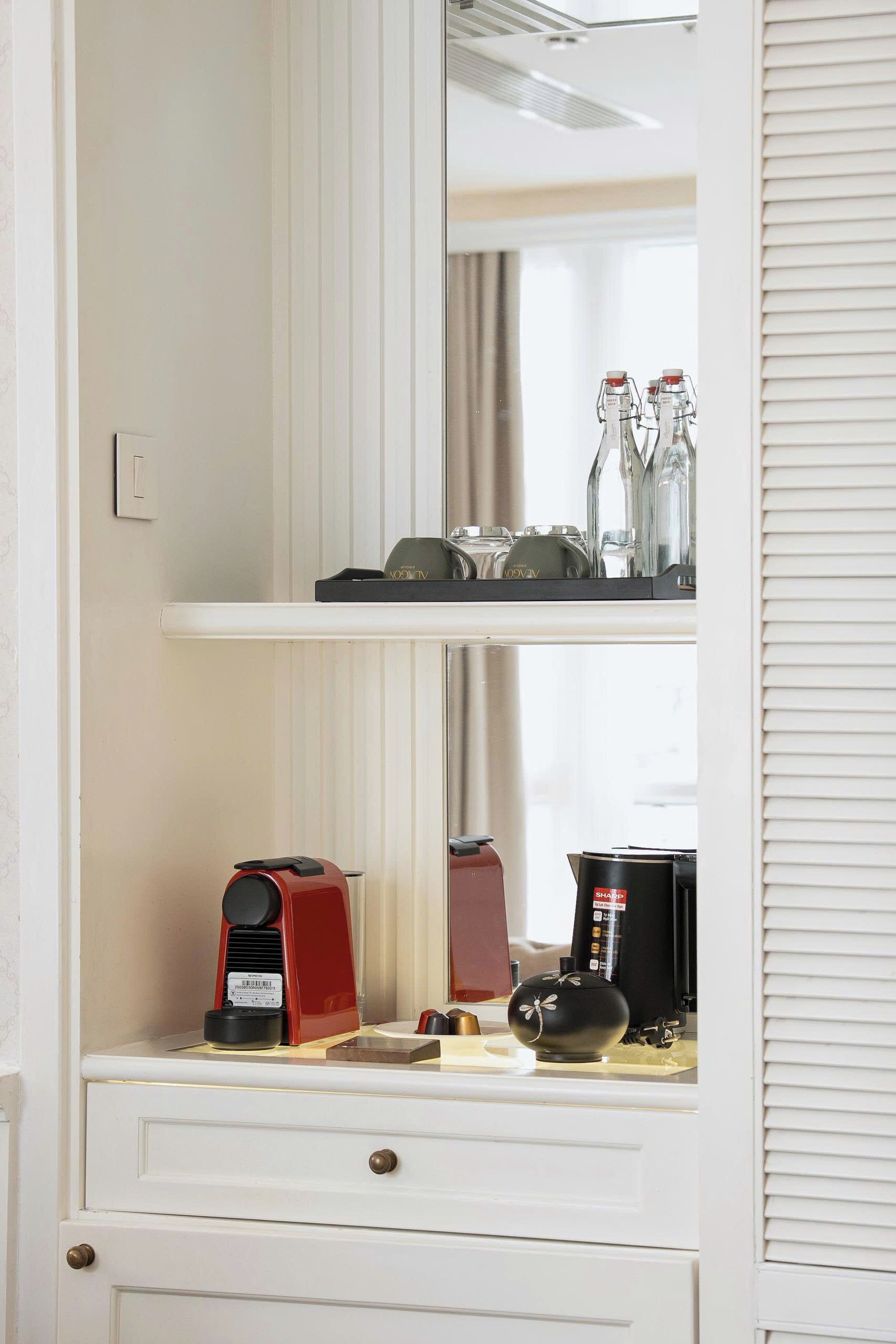A kitchen with a coffee maker, a kettle, and a teapot on the counter.