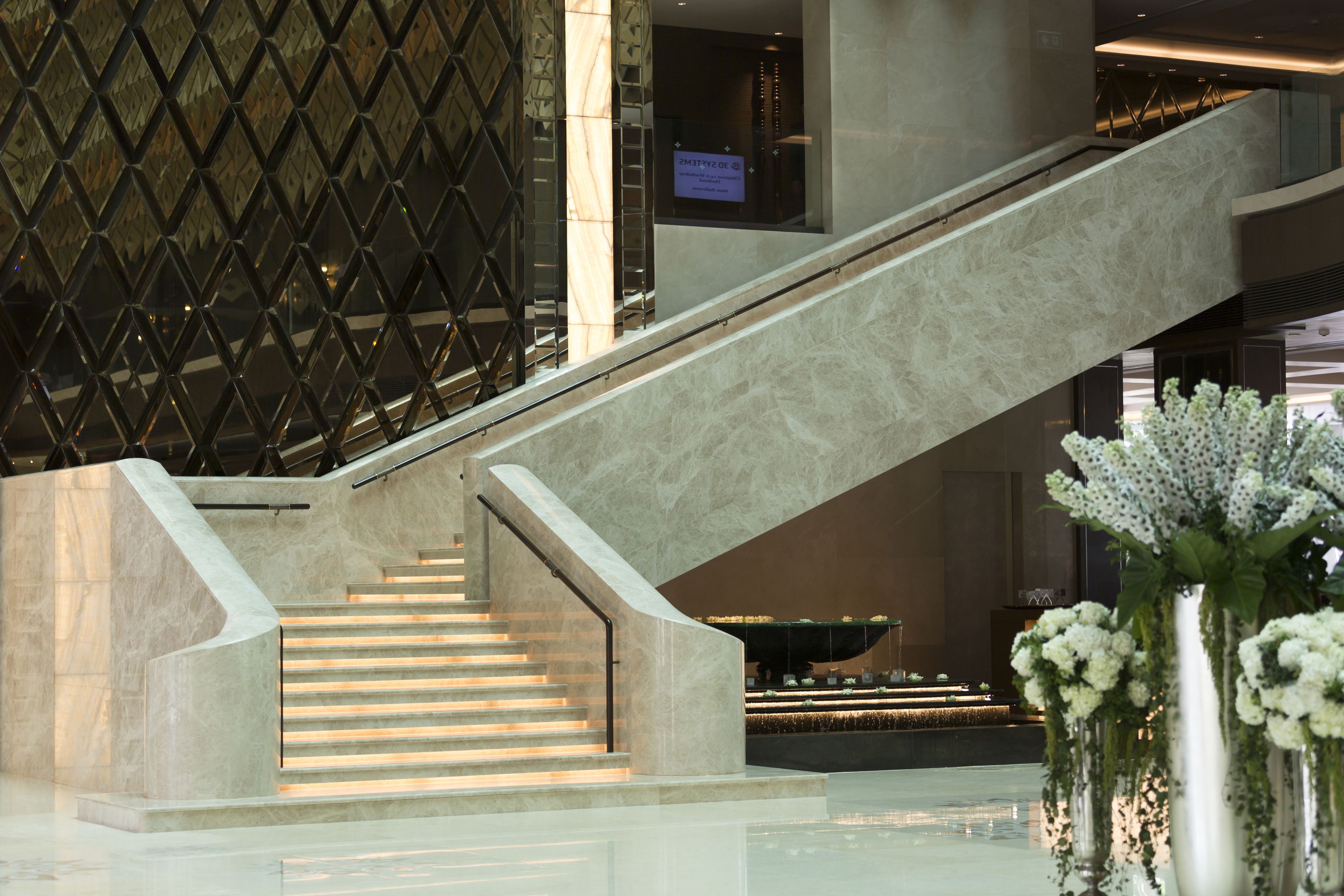 Ein modernes Interieur mit einer Marmortreppe, einer Wandverkleidung und einem Empfangsbereich.