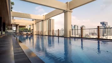 Una piscina al aire libre, sillones reclinables de piscina