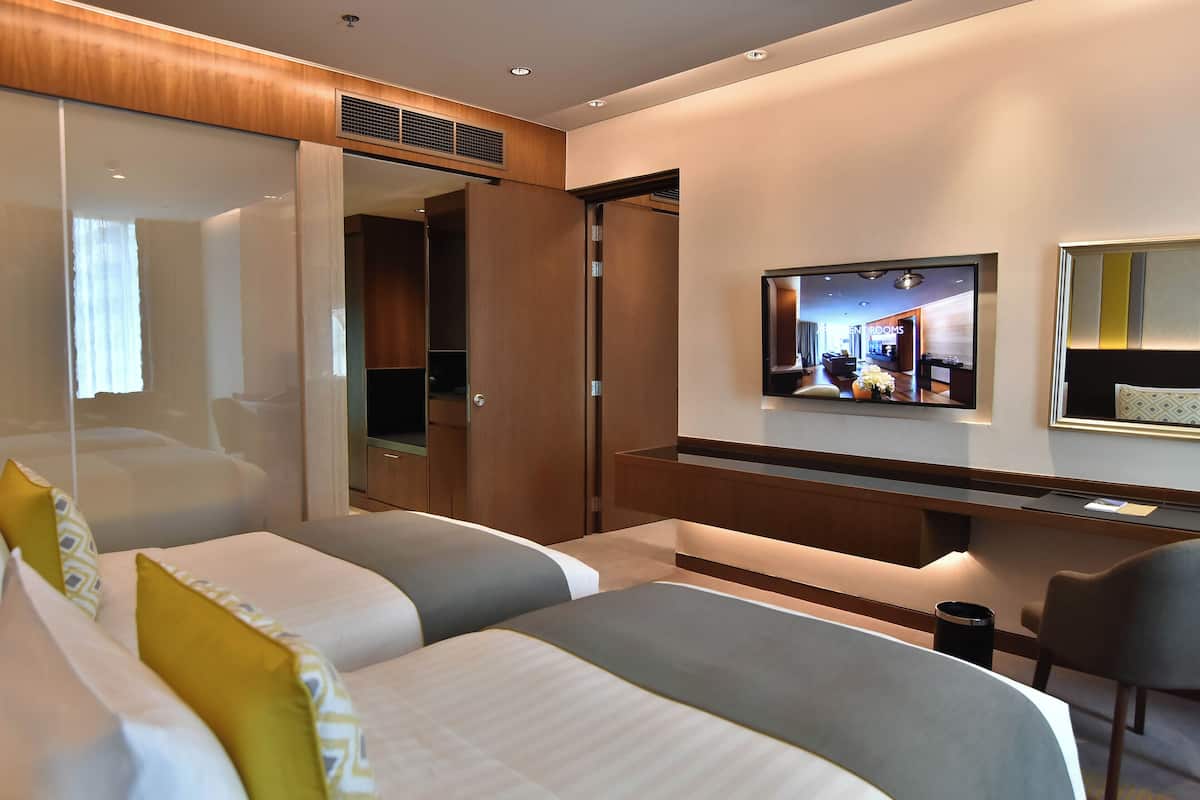 Een moderne hotelkamer met een groot bed, een bureau, een televisie en een kledingkast.