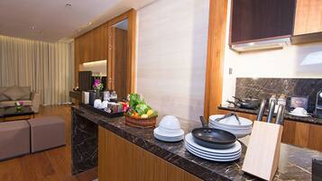A modern kitchen with a marble countertop, wooden cabinets, and a dining area with a sofa and a coffee table.