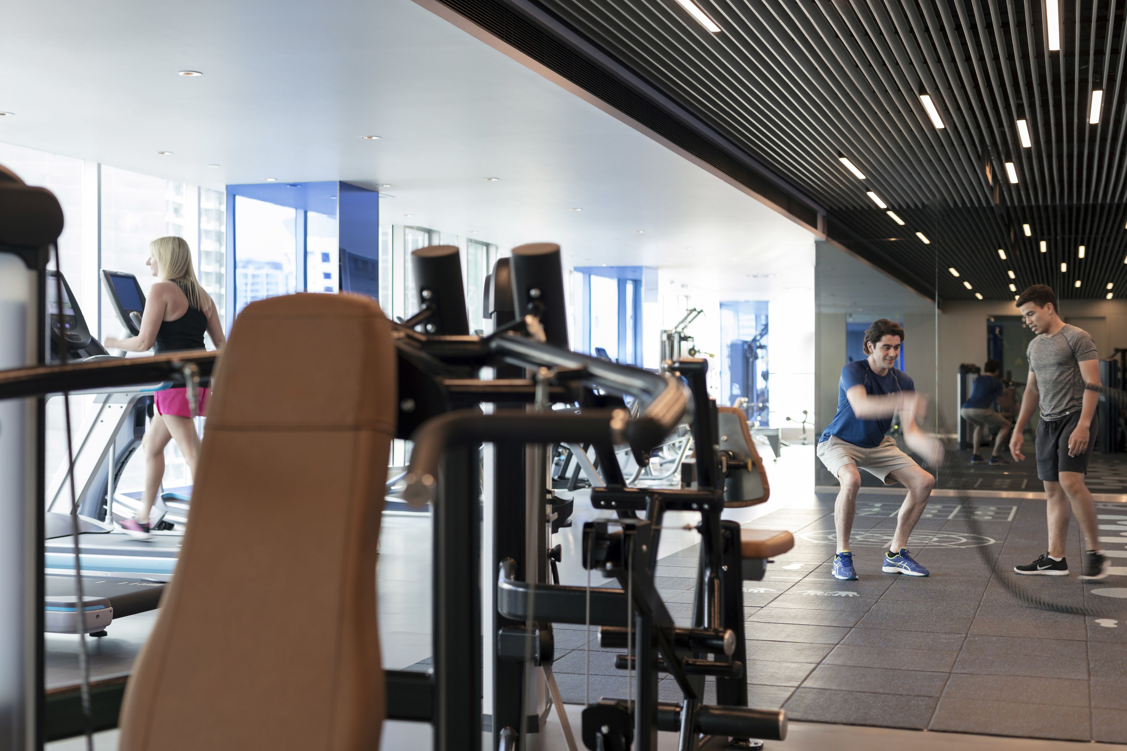 A gym with exercise equipment, a treadmill, and a mirror.