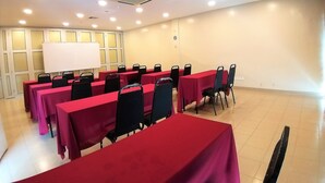 A conference room with multiple tables covered in red tablecloths and black chairs. - Hotel Jelai Raub (Raub)