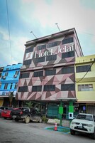 Un edificio de hotel con fachada geométrica y un letrero que dice 'Hotel Jelai'.