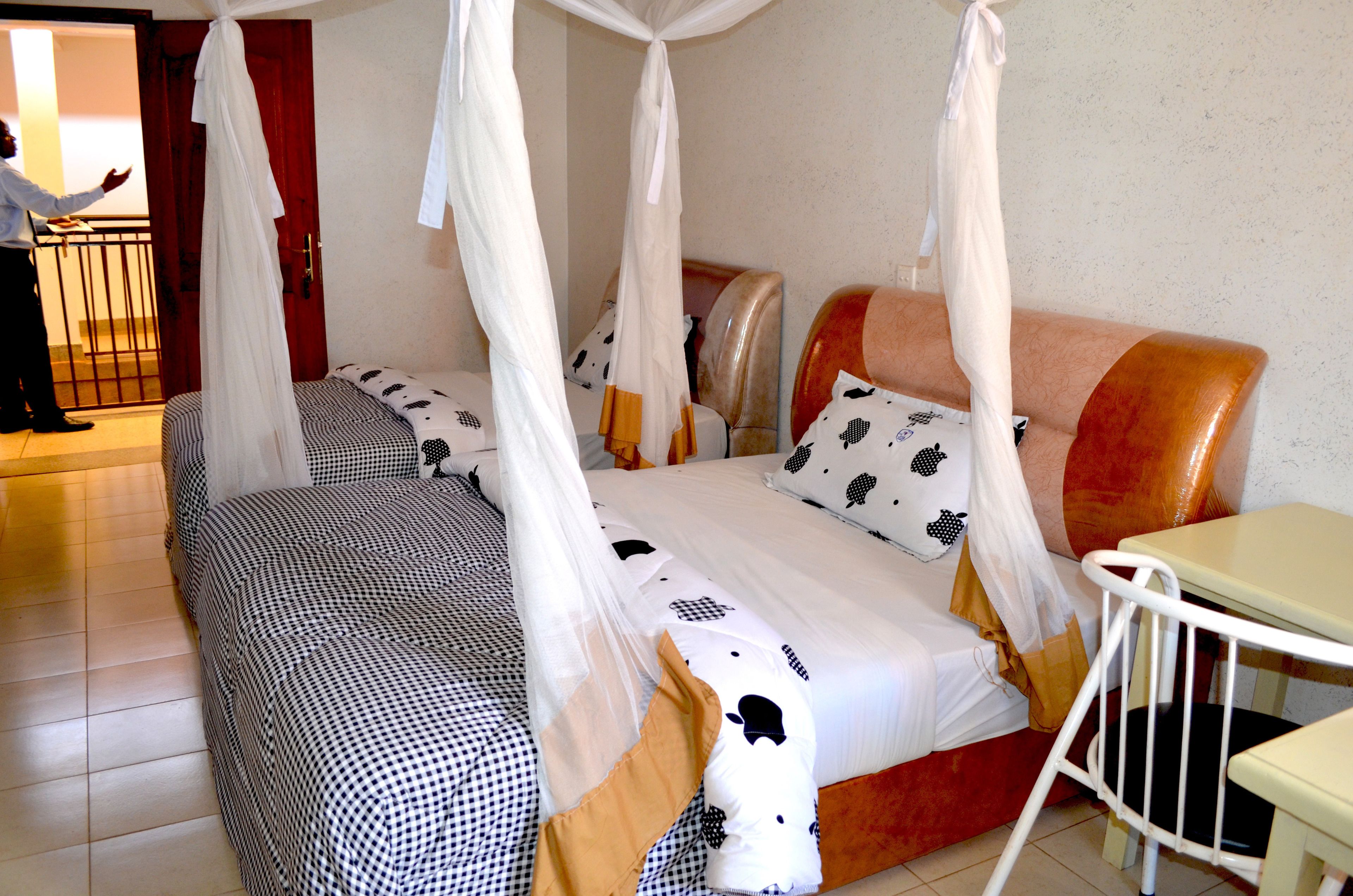 Un dormitorio con una cama con dosel, una mesita de noche y una silla.