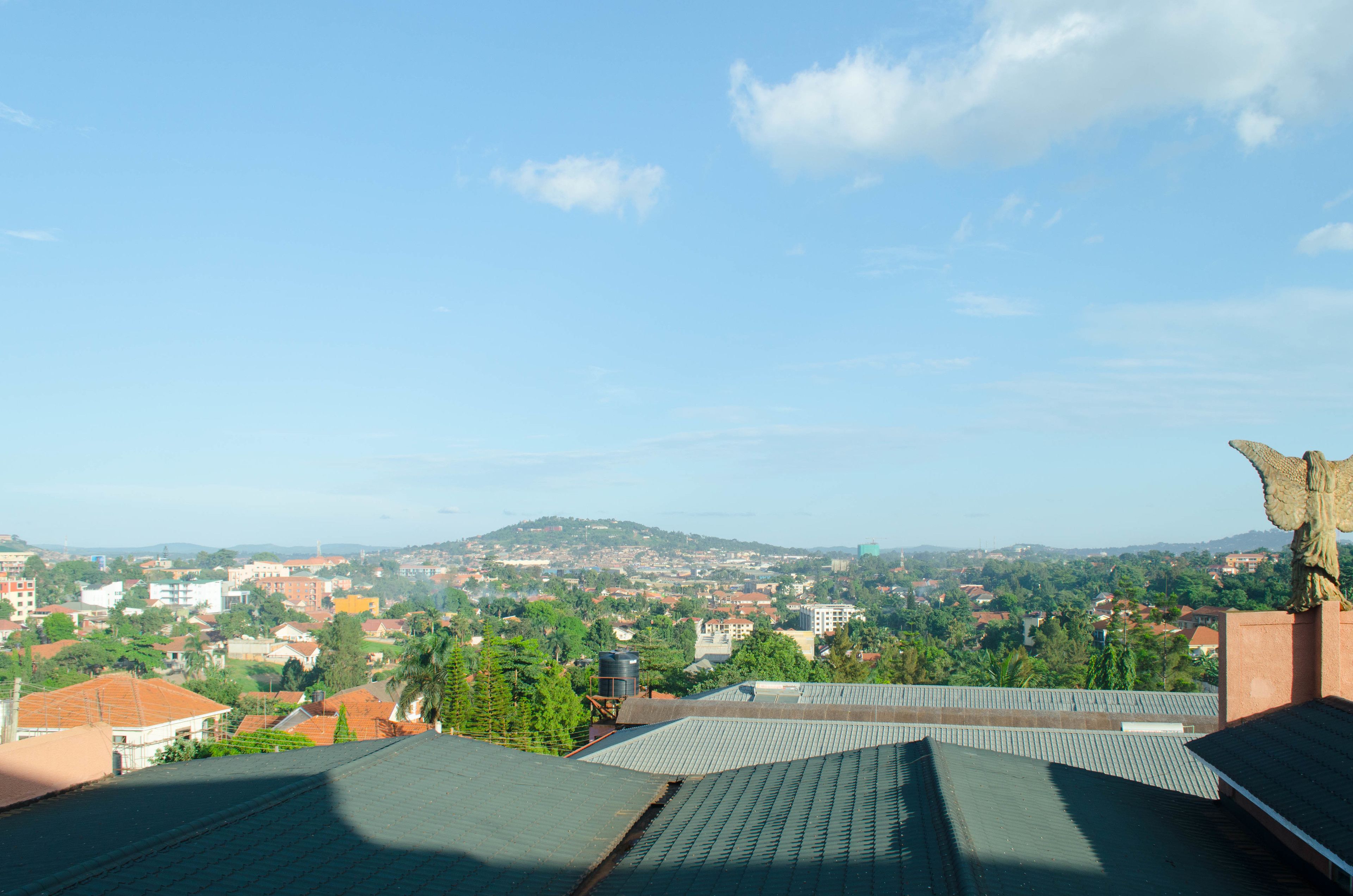 A view of a cityscape with a statue on a rooftop.