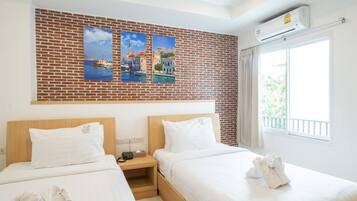 Une chambre d’hôtel avec deux lits, un mur en briques et une fenêtre donnant sur un paysage agréable.