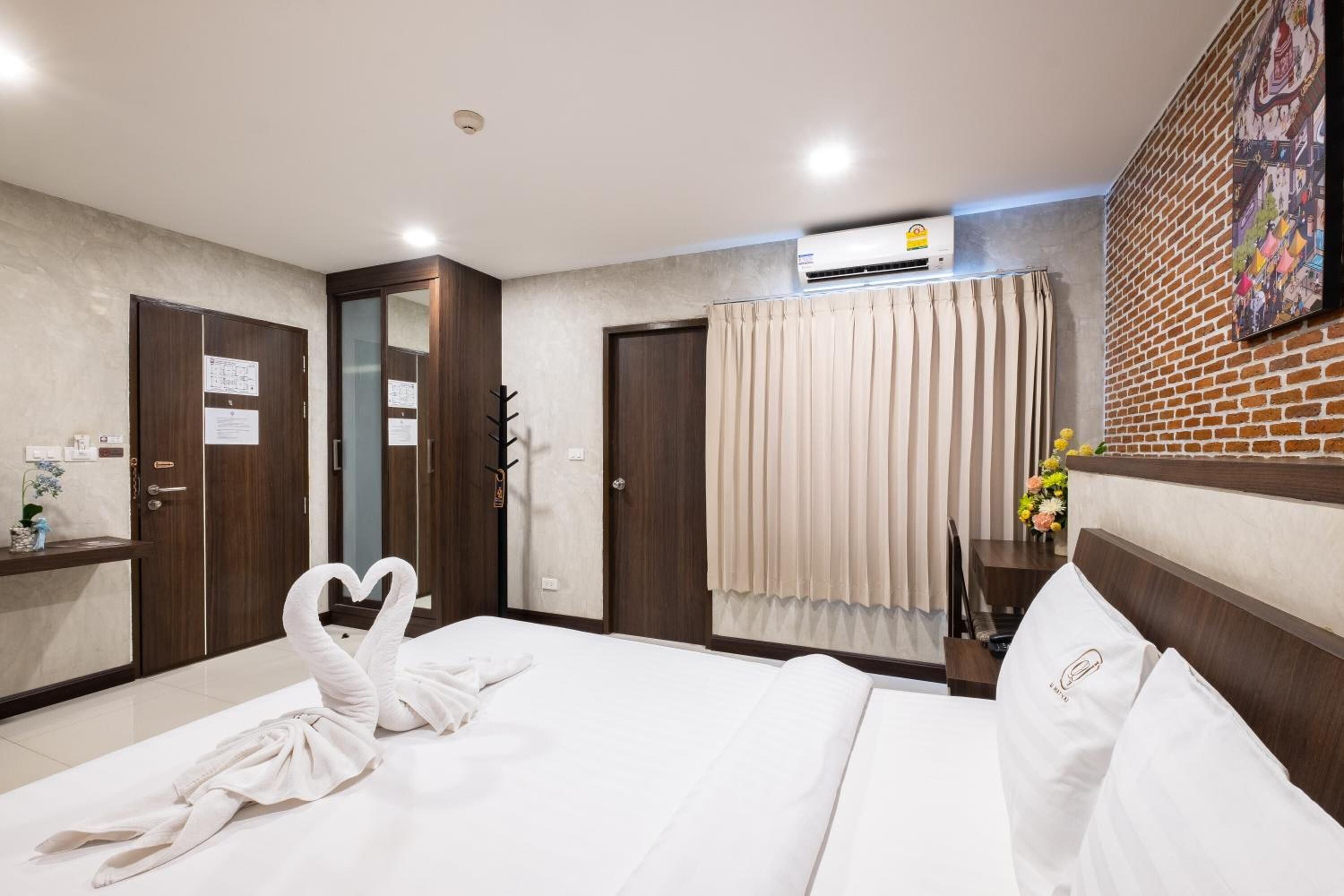A hotel room with a bed, a desk, a wardrobe, and a bathroom.