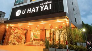 Un moderno edificio de hotel con un letrero que dice 'U HAT YAI'.