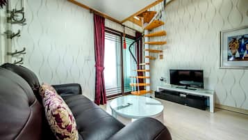 Standaard kamer | Woonruimte | Een 35-inch flatscreentelevisie met kabelzenders en televisie